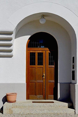 Zweiflügelige Haustür aus Holz im Rundbogen-Portal
