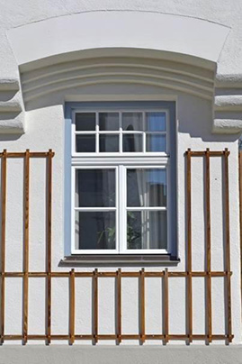 Weißes Holz-Alu-Fenster mit Sprossen in einer Altbaufassade