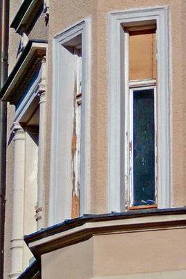 Sanierungsbedürftige Holzfenster an einer Altbaufassade